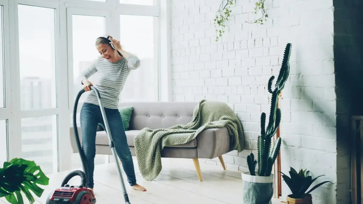 Professional cleaner tidying a bright modern living room