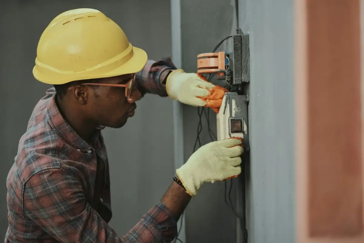Electrician installing wiring inside a consumer unit